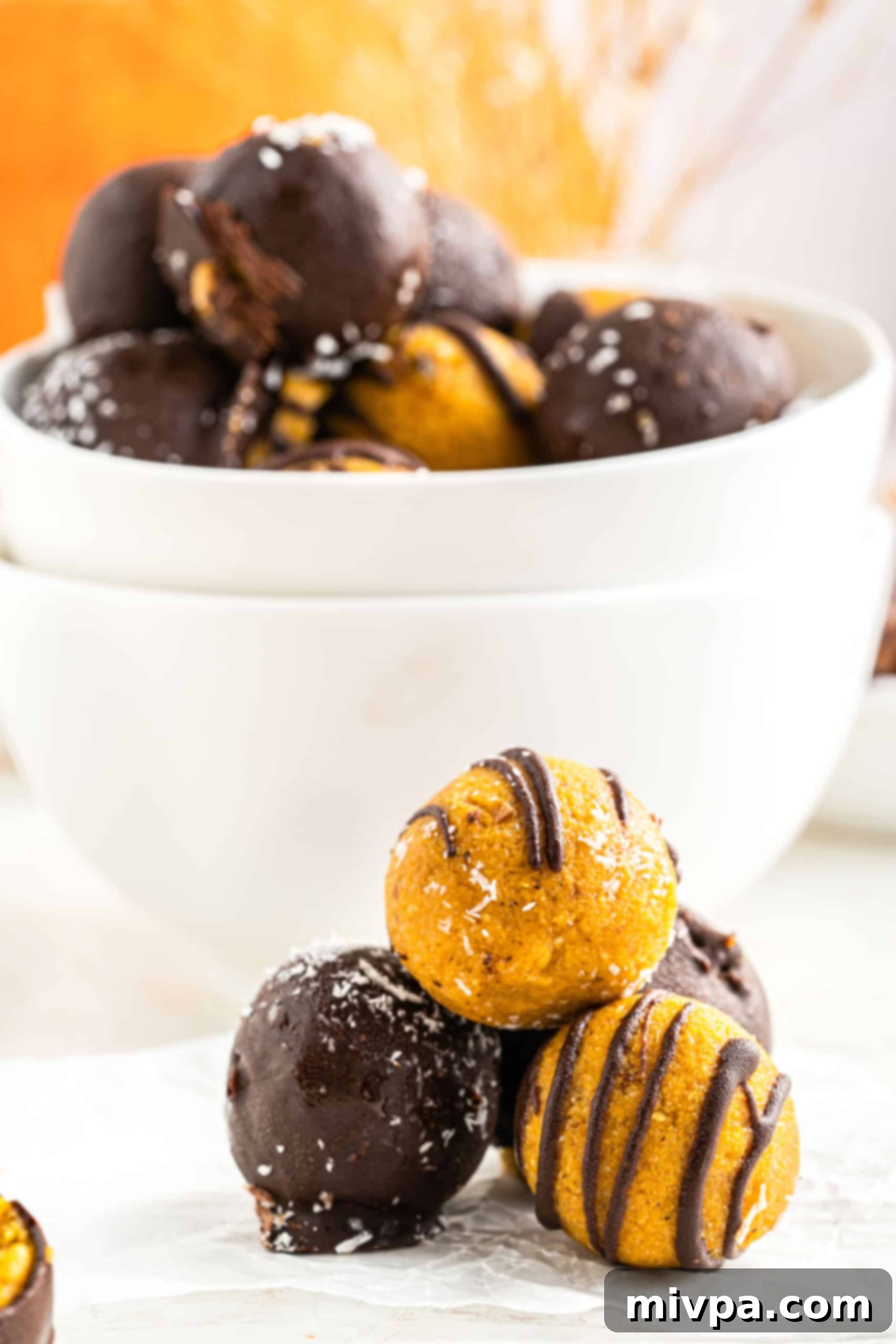 No-Bake Chocolate Pumpkin Pie Truffles (Gluten-Free, Vegan) An up-close shot revealing the rich chocolate coating and smooth pumpkin filling of these no-bake truffles.