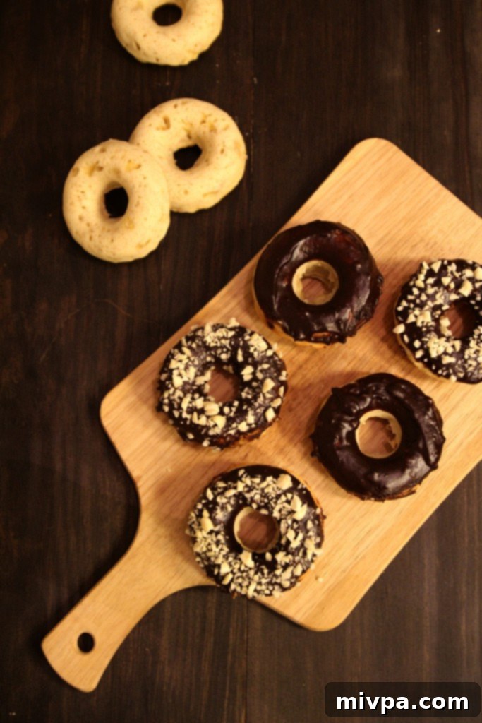 Baked Banana Doughnuts with Chocolate Glaze and Almonds on a white plate