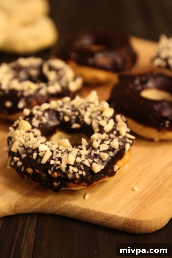 Baked Banana Doughnuts with Chocolate Glaze and Almonds on a cooling rack