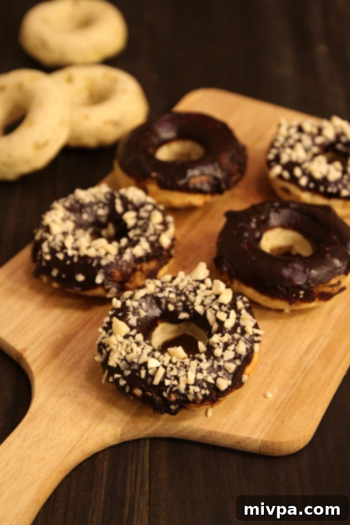 Baked Banana Doughnuts with Chocolate Glaze and Almonds on a plate with coffee