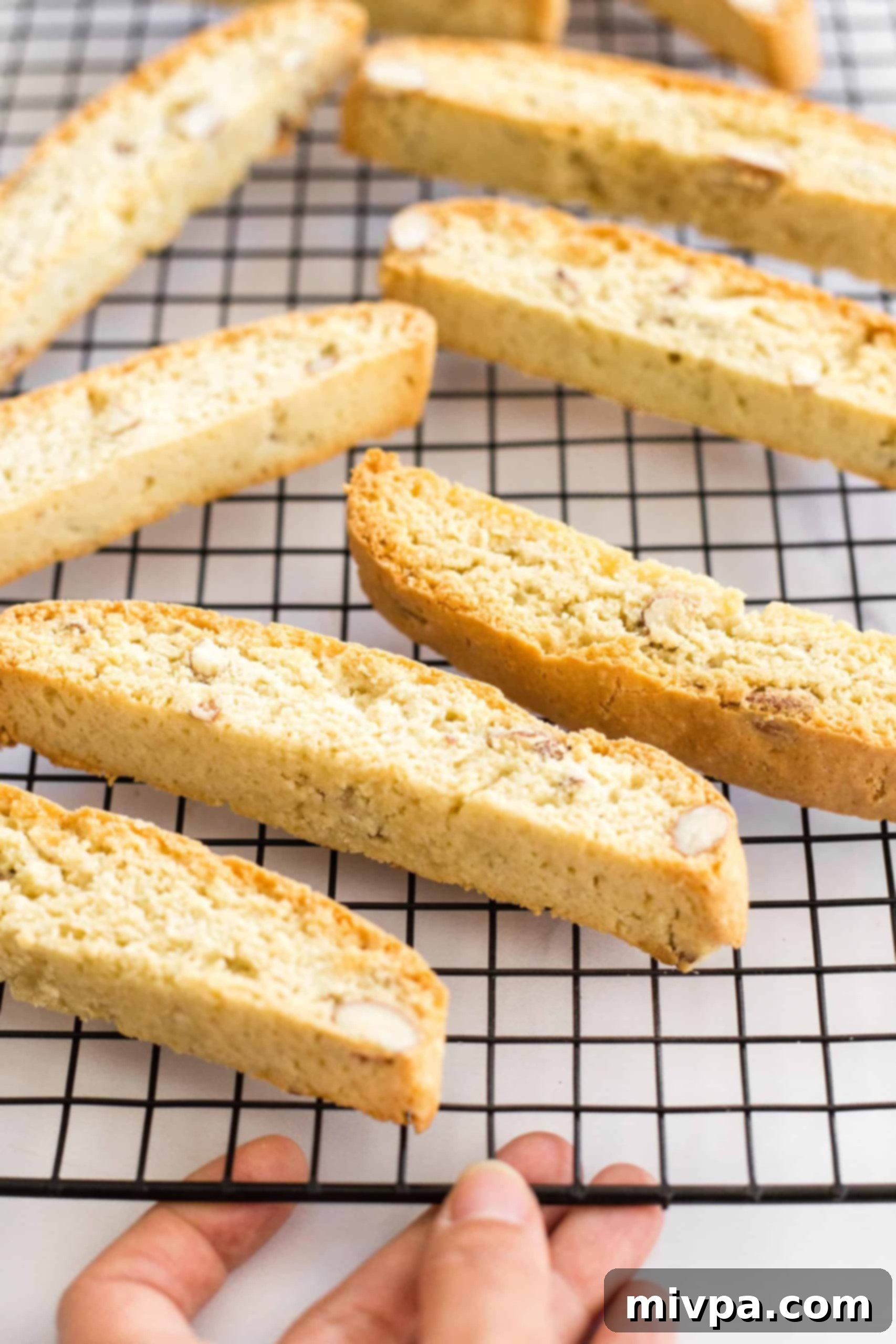 Cooling gluten-free almond biscotti arranged neatly on a wire rack, allowing them to achieve their final crispy texture.