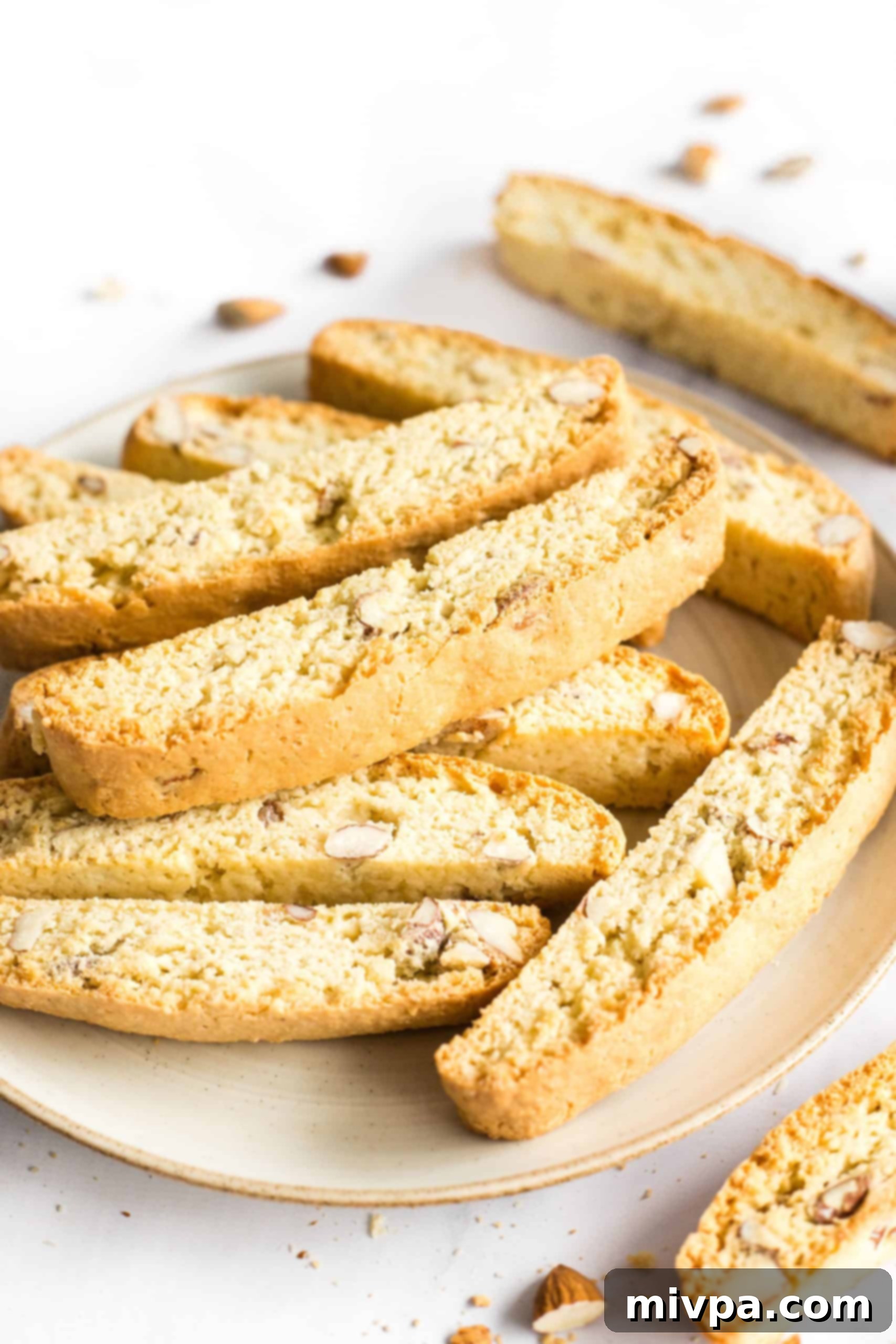 A close-up shot of golden-brown gluten-free almond biscotti, showcasing its perfect texture and visible almond pieces.