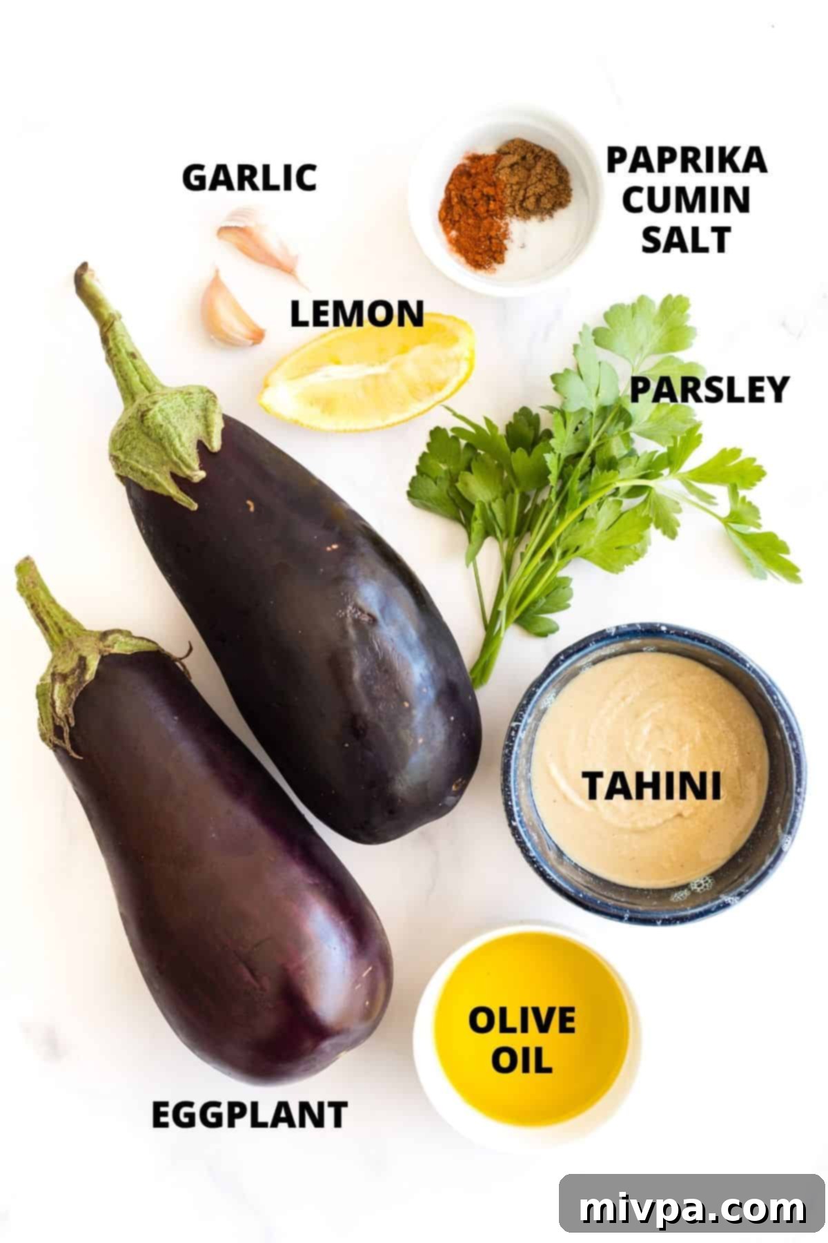 Labeled ingredients for baba ganoush recipe laid out on white board.