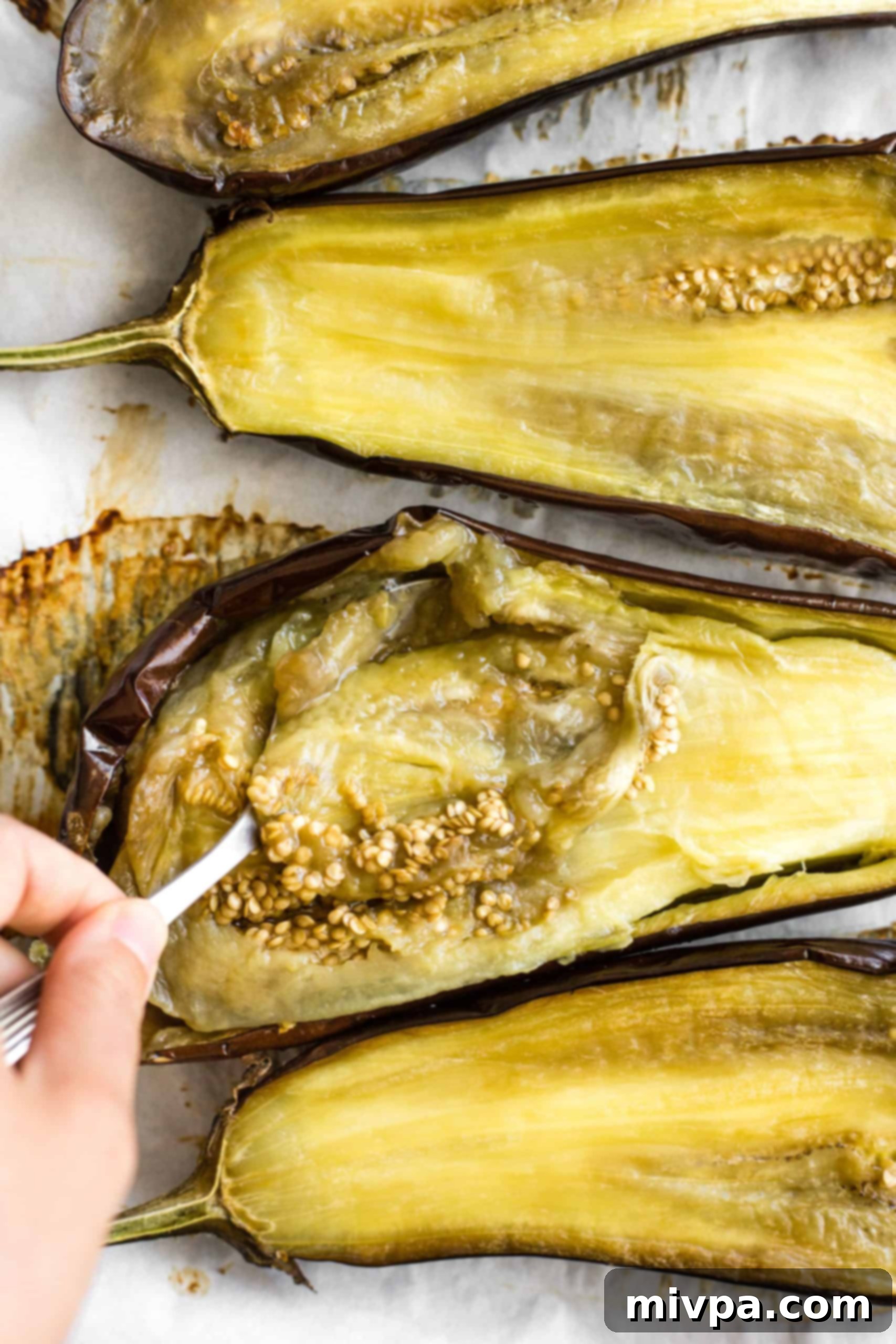 Scooping out the flesh from roasted eggplant.