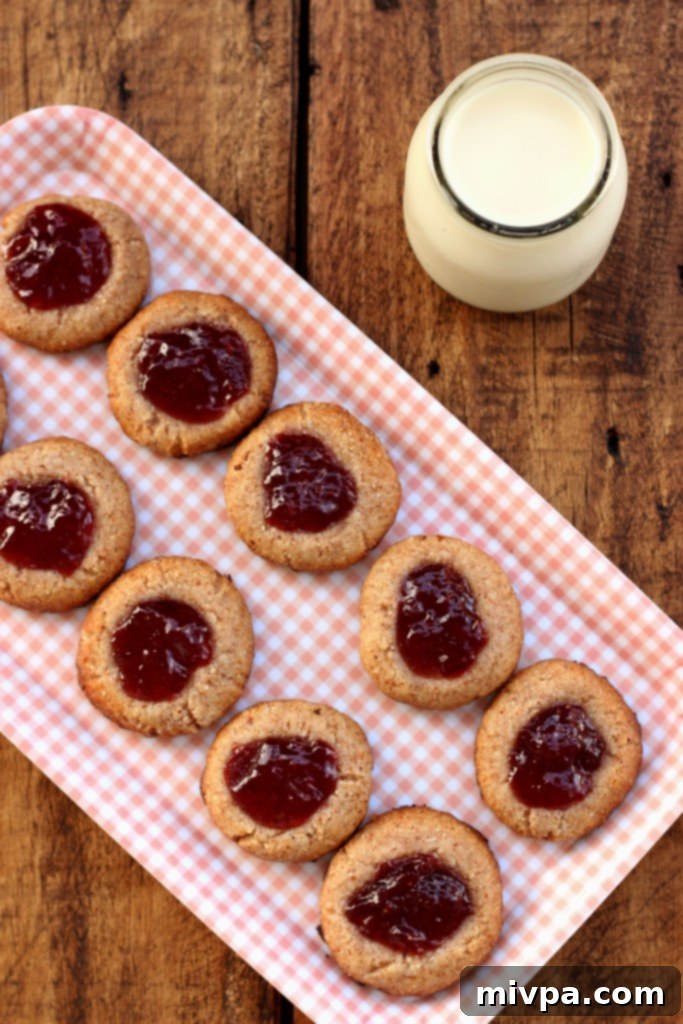 Berry-Kissed Grain-Free Thumbprints 3 Several grain-free strawberry thumbprint cookies on a cooling rack