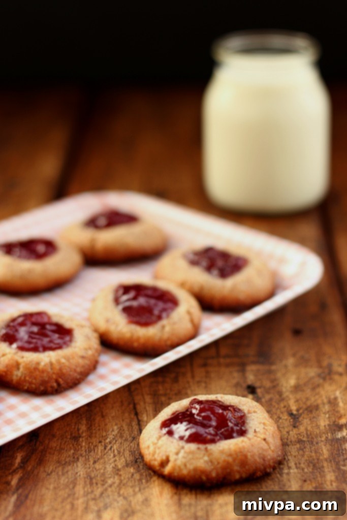 Berry-Kissed Grain-Free Thumbprints 5 Single grain-free strawberry thumbprint cookie with a bite taken
