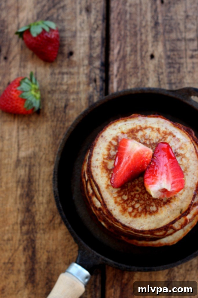 Stack of grain-free pancakes with strawberries and honey
