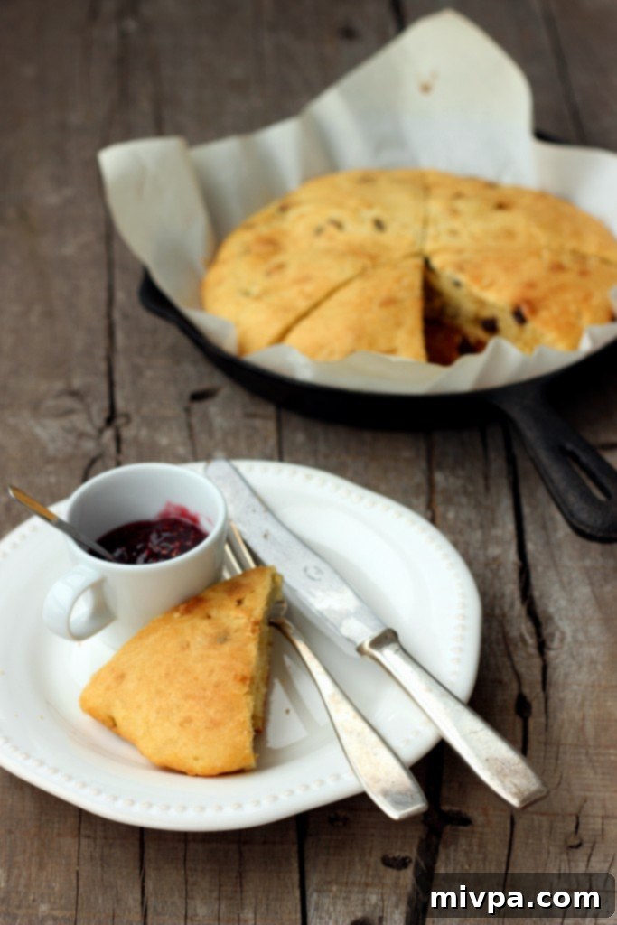A hand reaching for a Gluten-free Raisin Scone
