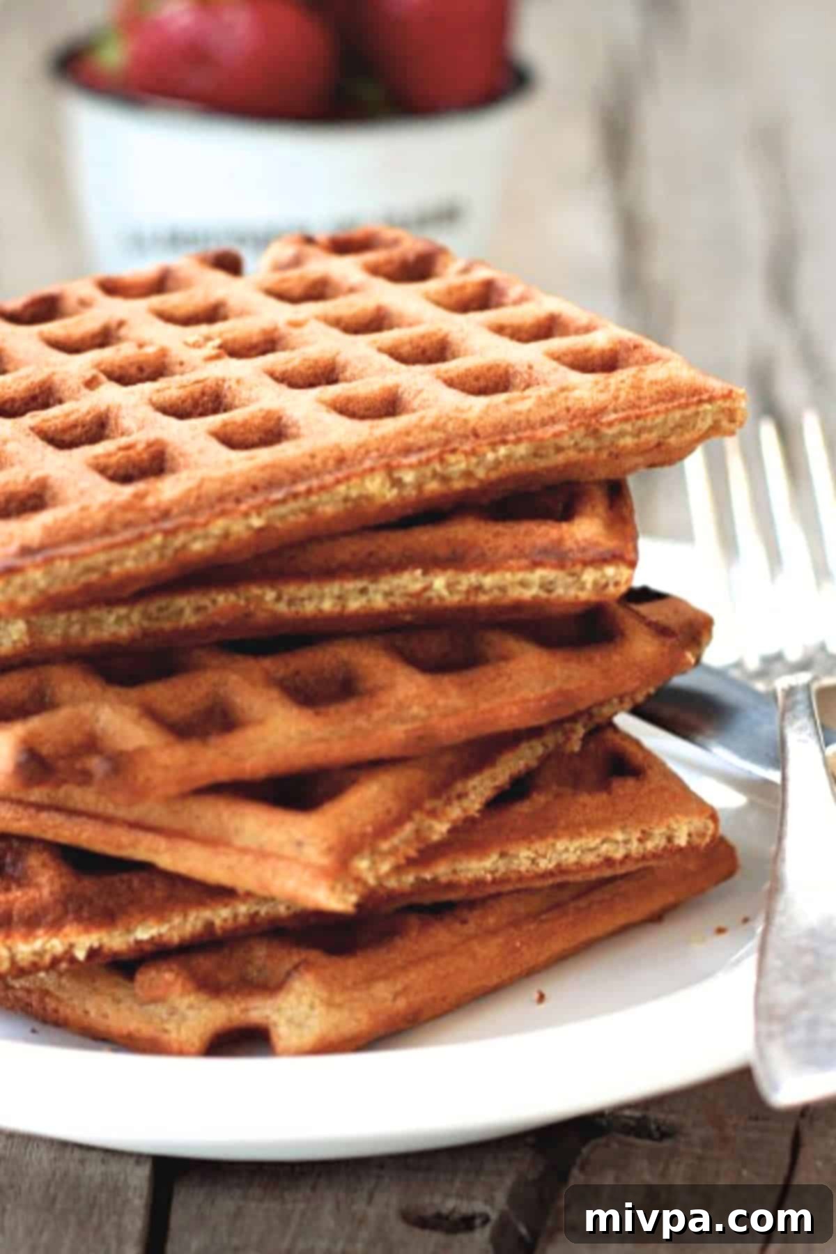 A stack of oat flour waffles on plate, ready to be served for breakfast.