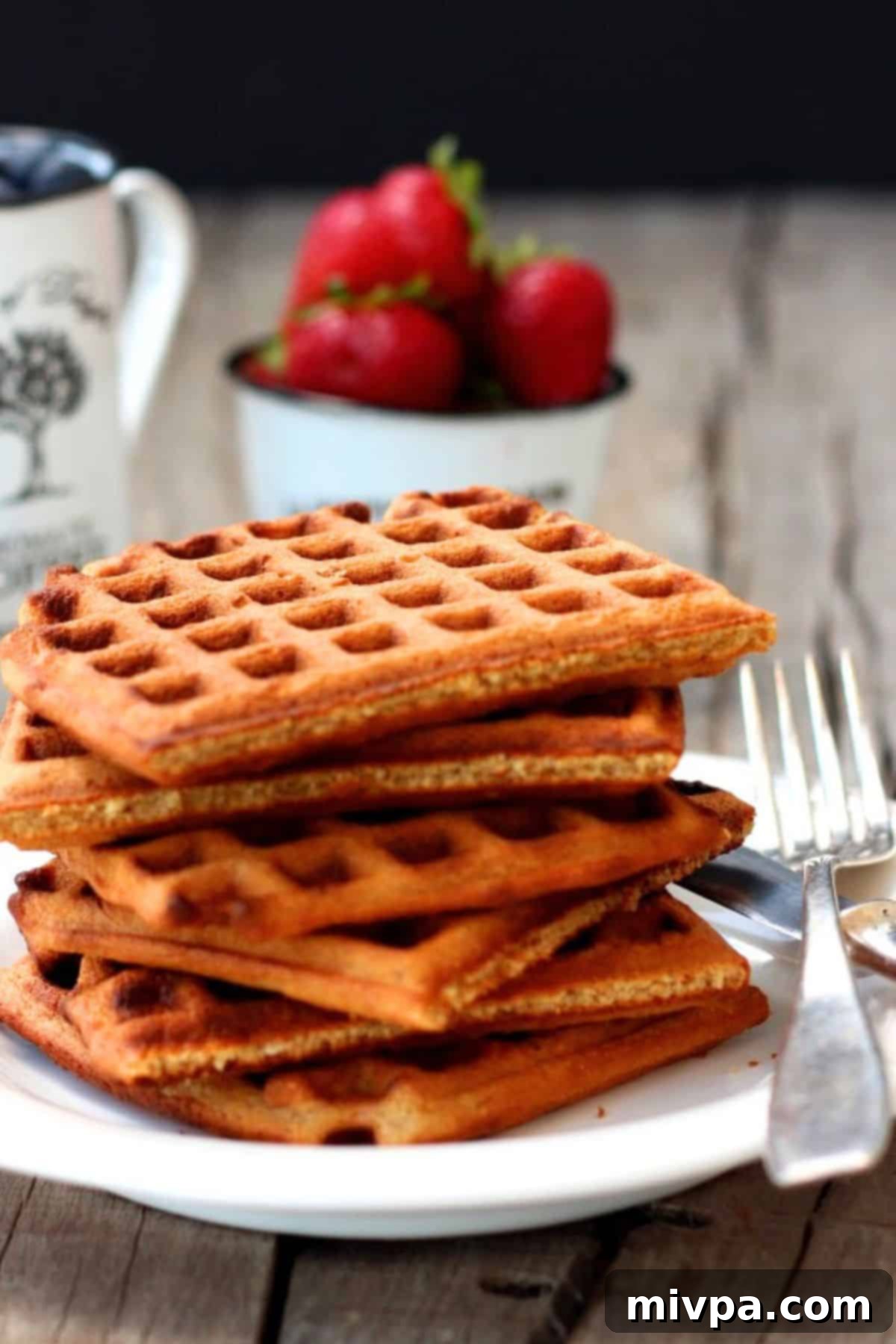 Up close shot of oat flour waffles on a plate, highlighting their crispy texture.