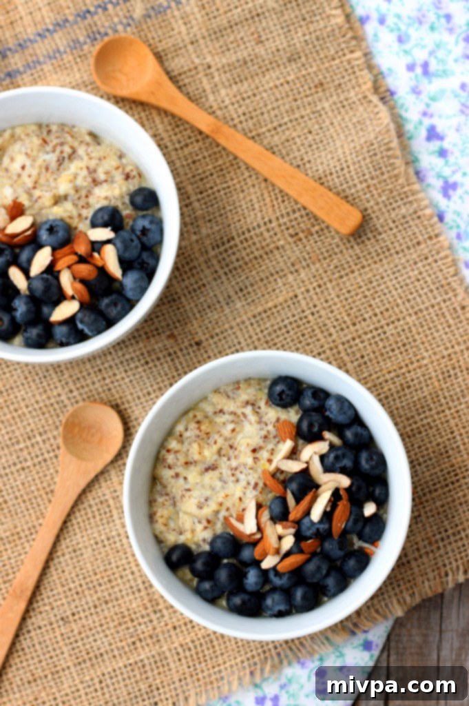 Overhead shot of a bowl of Blueberry & Almond Flaxseed Porridge with fresh berries and nuts