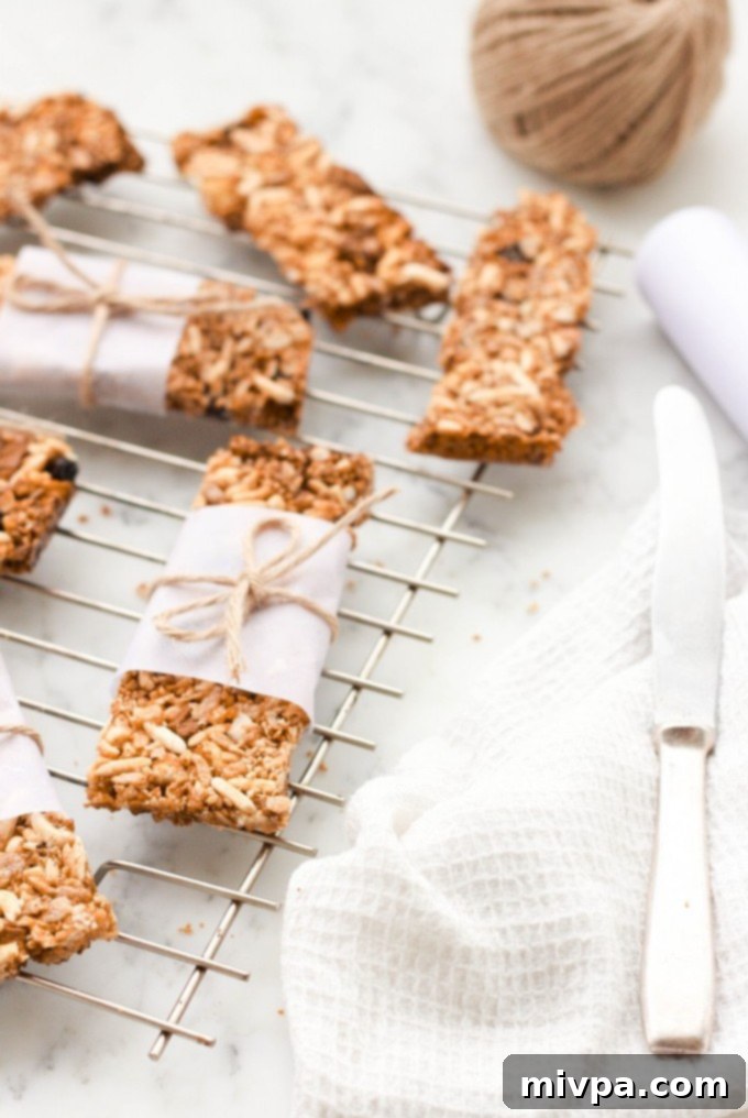 Homemade granola bars individually wrapped in parchment paper and tied with twine, ready for gifting or on-the-go.