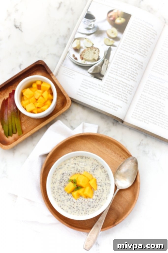 Mango Chia Pudding (Gluten-Free, Vegan) Chia seed pudding topped with fresh mangoes and mint on a wooden plate, ready to be enjoyed.