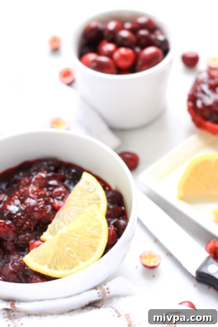 20-Minute Gluten-Free Cranberry Sauce (Dairy-Free, Vegan) A bowl of gluten-free cranberry sauce with two lemon wedges.