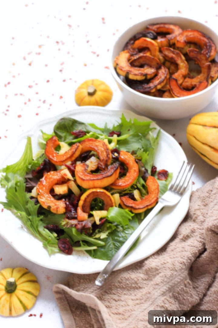 Roasted Delicata Squash Salad (Gluten-Free, Vegan) A plate of roasted delicata squash salad next to brown kitchen towel.