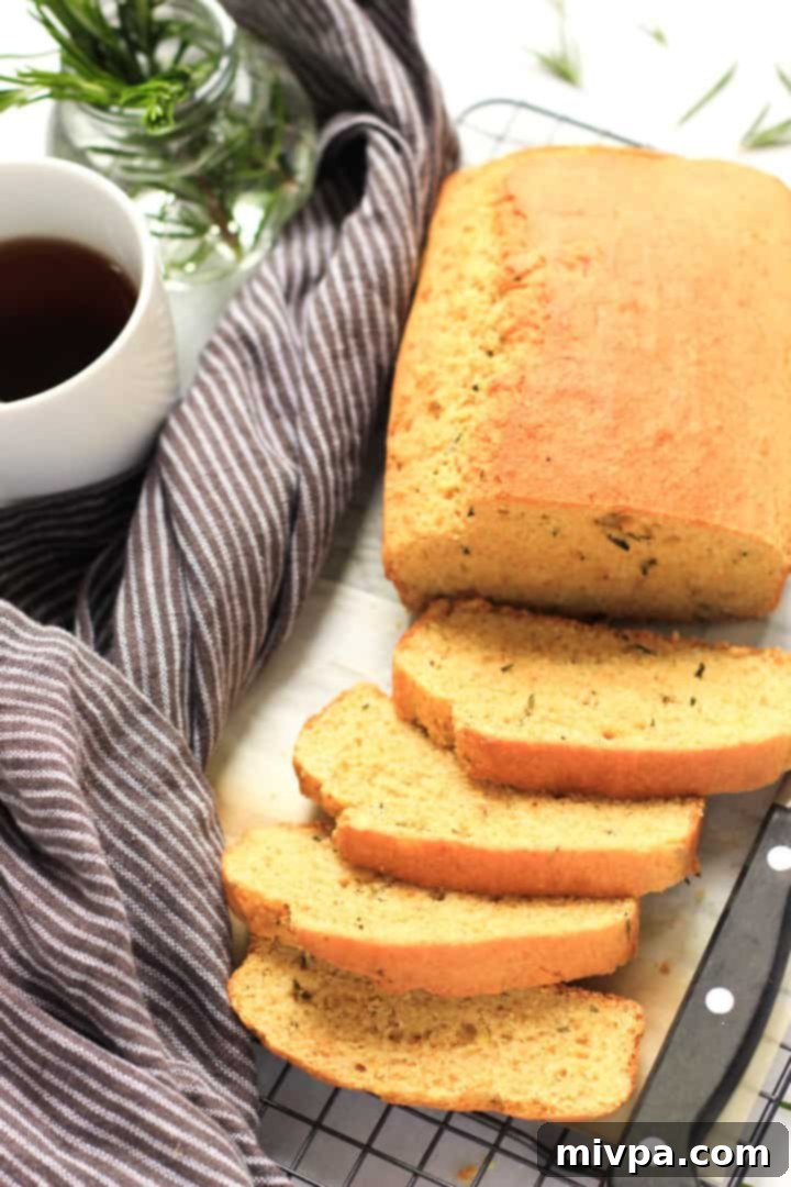 A cup of tea and sliced rosemary cornbread on a cooling rack.