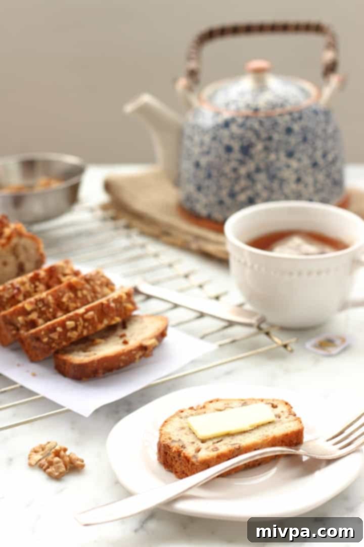 Gluten-free Banana Walnut Bread - A loaf of banana bread being sliced, showing its moist interior and walnuts.