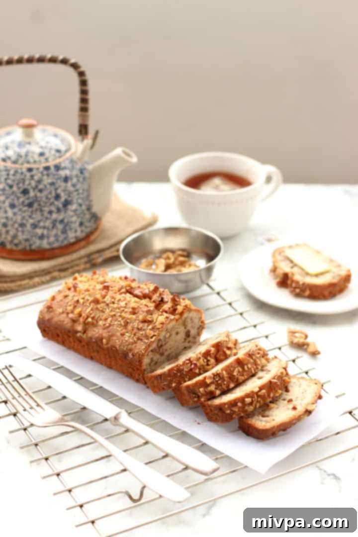Gluten-free Banana Walnut Bread - A full loaf of banana walnut bread with a few slices cut, showing a rich texture.