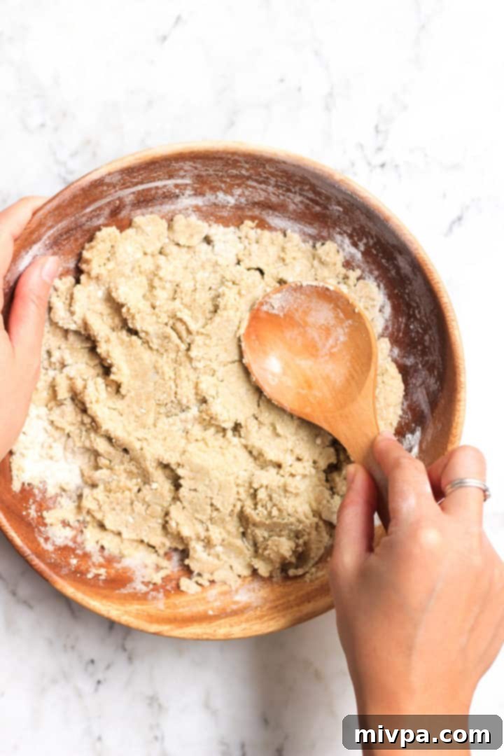 Easy Buckwheat Cookies (Gluten-Free, Dairy-Free) Using a wooden spoon to mix buckwheat cookie dough in a bowl.