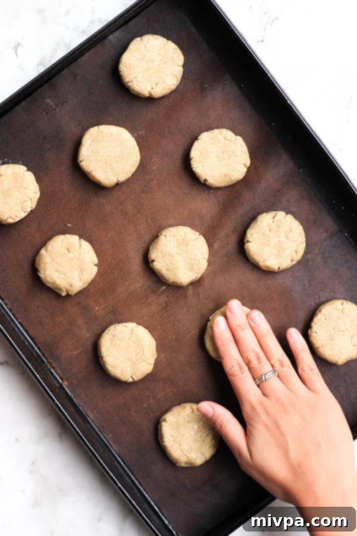 Easy Buckwheat Cookies (Gluten-Free, Dairy-Free) Flattening gluten-free buckwheat cookie dough on a cookie sheet.
