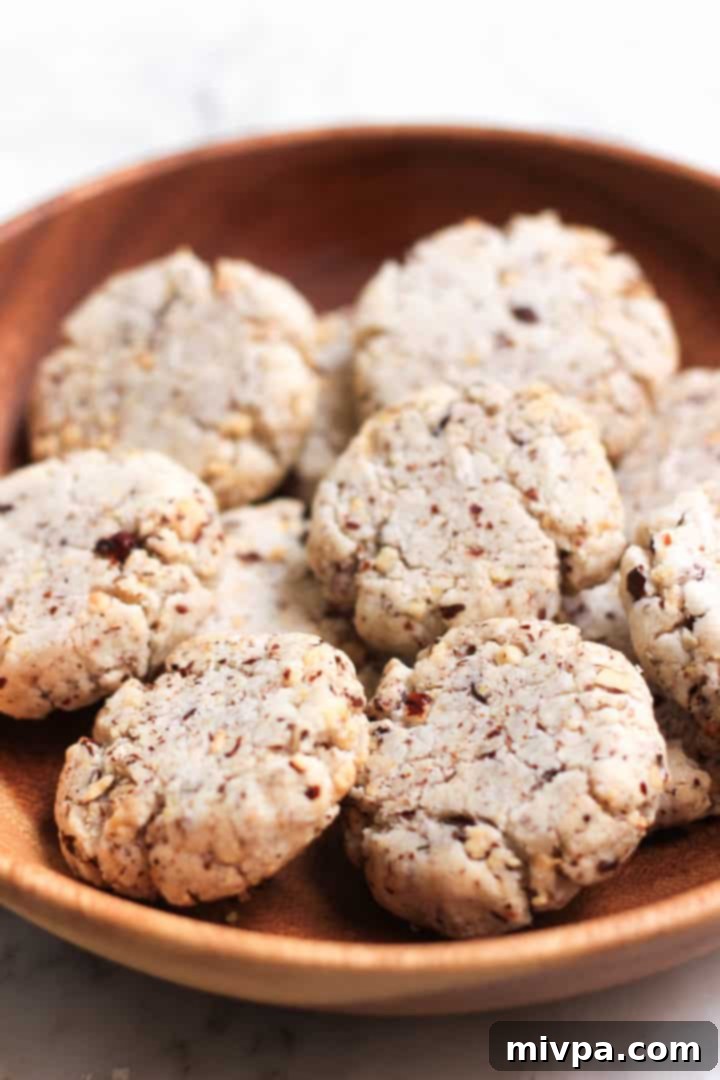 A wooden bowl filled with beautifully baked gluten-free hazelnut cookies.