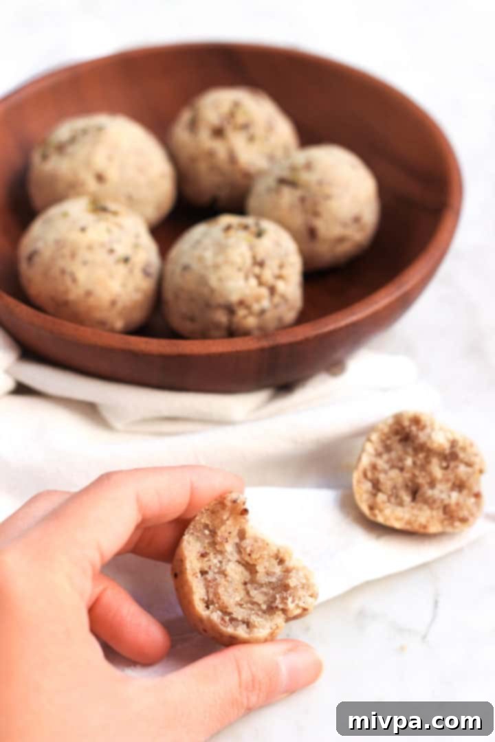 Six small, perfectly round gluten-free bread rolls, golden and inviting, cooling on a wire rack after baking.