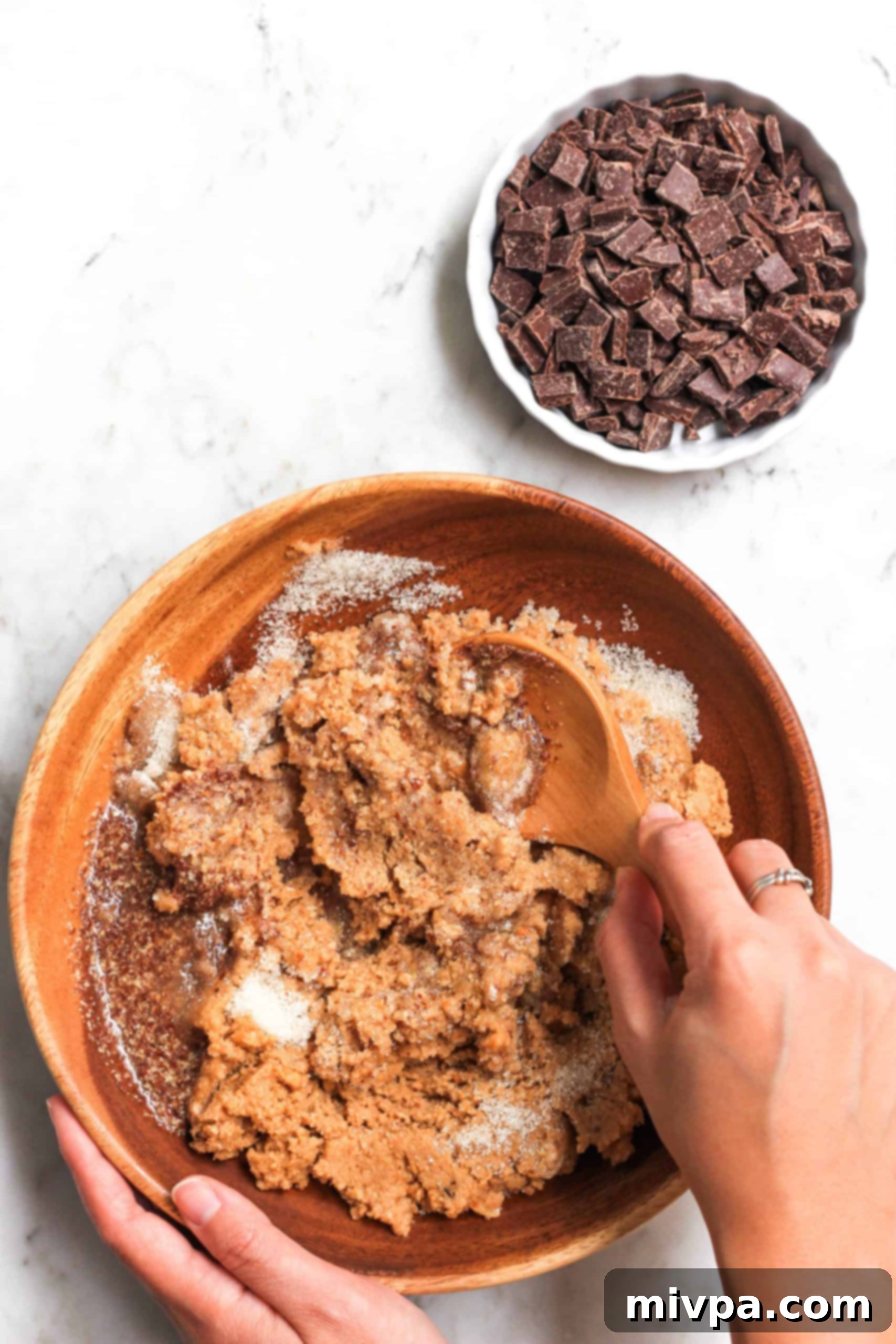 Easy Cashew Butter Cookies (Gluten-Free, Dairy-Free, Vegan) Mixing cashew butter cookie dough in a wooden bowl.