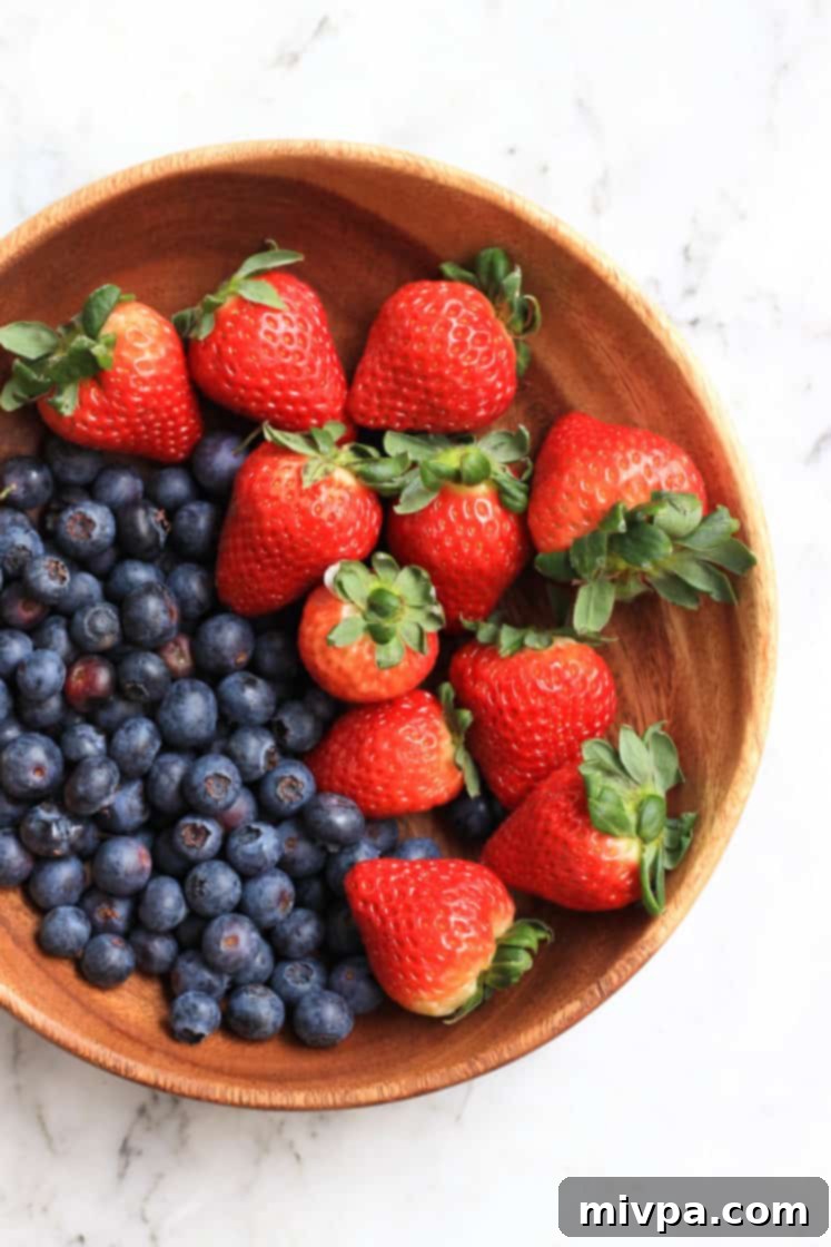 Easy Mixed Berry Chia Jam (Gluten-Free, Vegan) A wooden bowl overflowing with fresh, vibrant berries