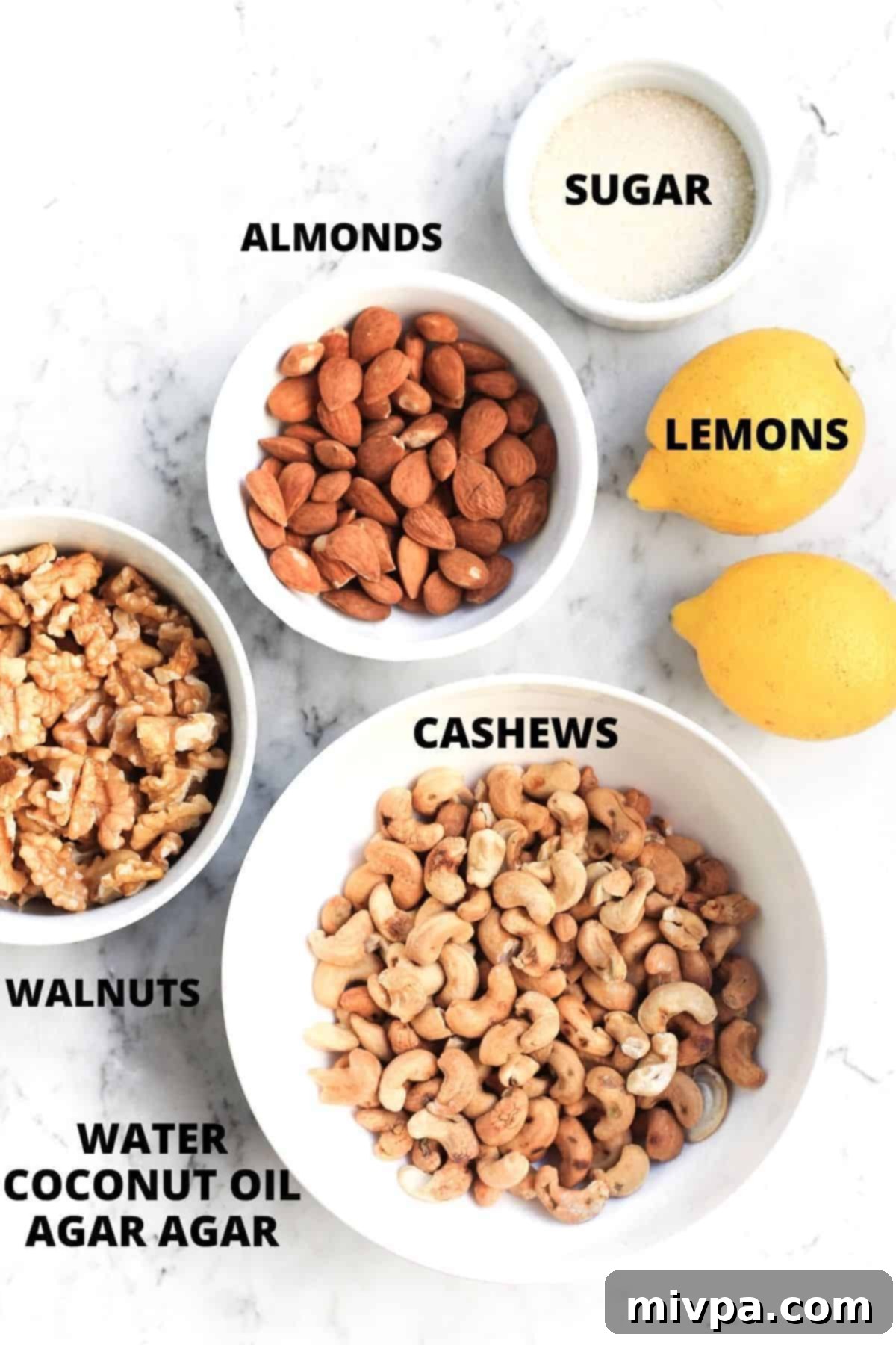 Top down view of ingredients for vegan lemon cheesecake recipe laid out on marble board.
