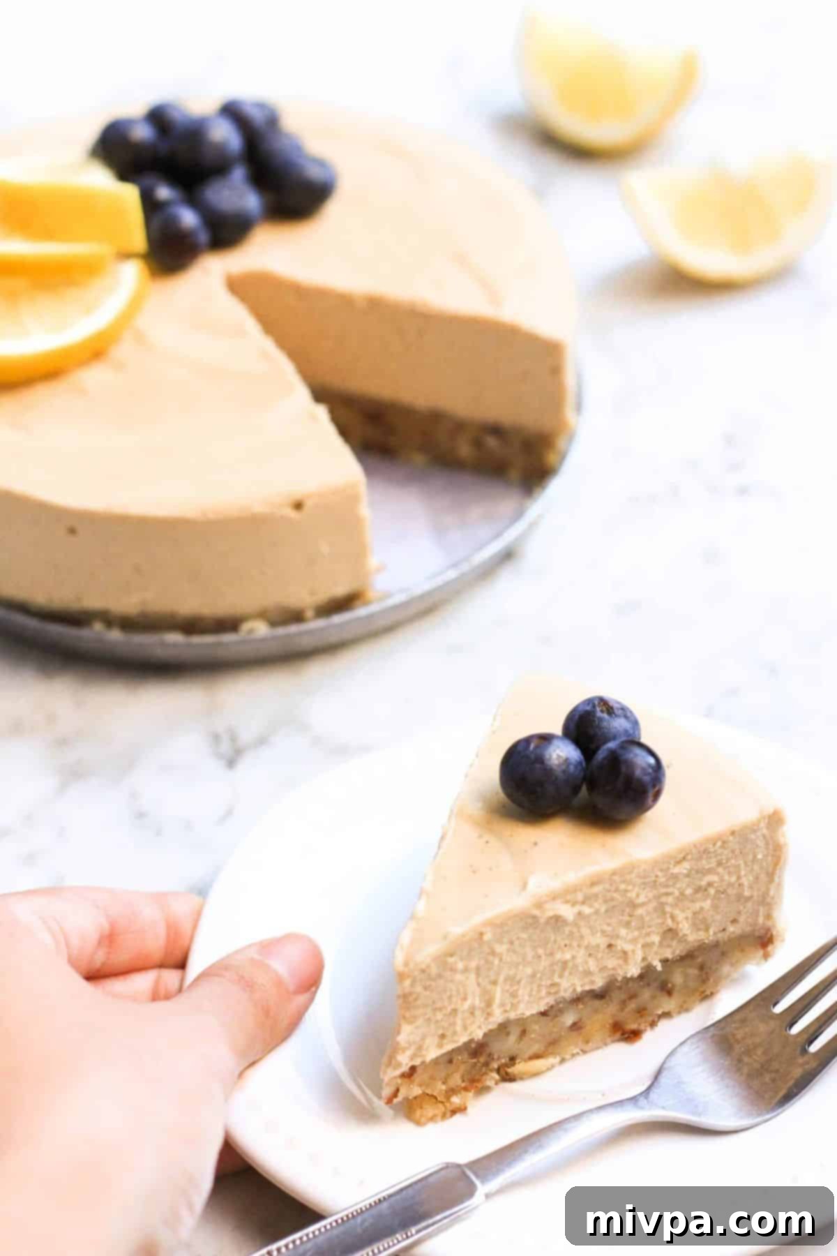Reaching for a plate with a slice of no-bake lemon cheesecake.