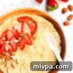 Top down view of a bowl of millet porridge with fresh strawberries.