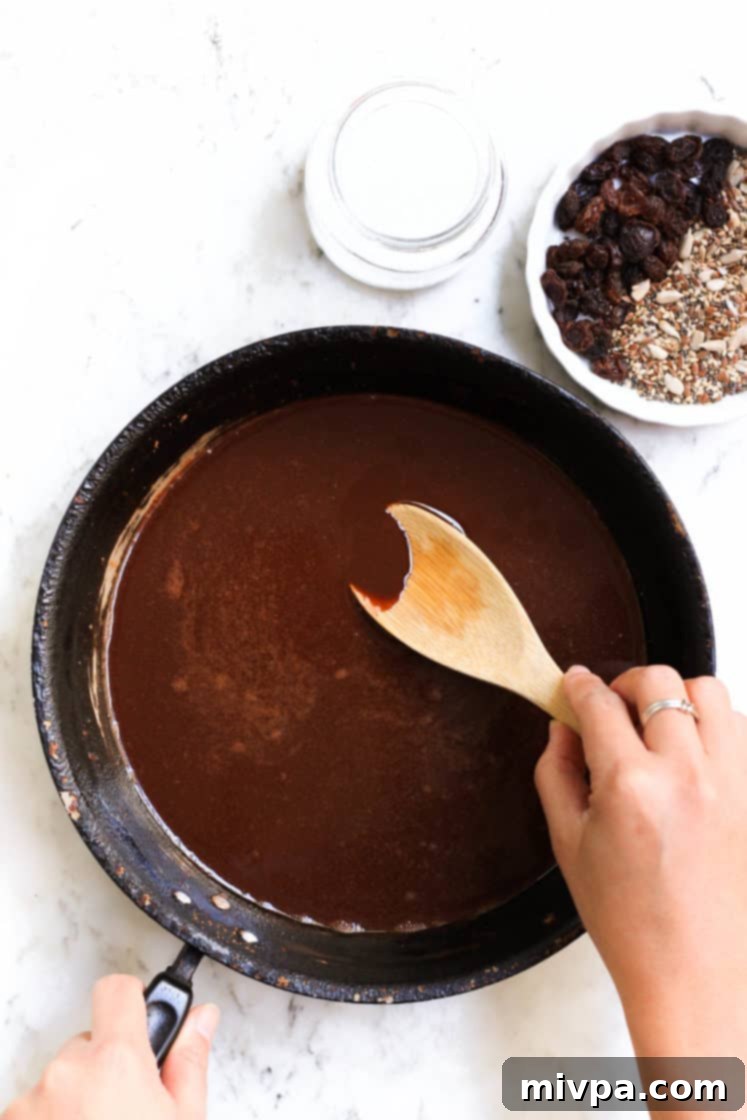 Easy Homemade Chocolate (Gluten-free, Vegan) Stirring chocolate mixture in a pan until smooth.