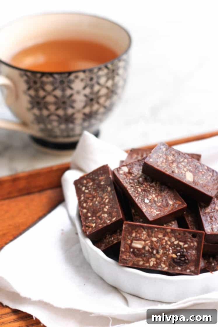 Easy Homemade Chocolate (Gluten-free, Vegan) Up close shot of homemade raisin and seed chocolate in a bowl.