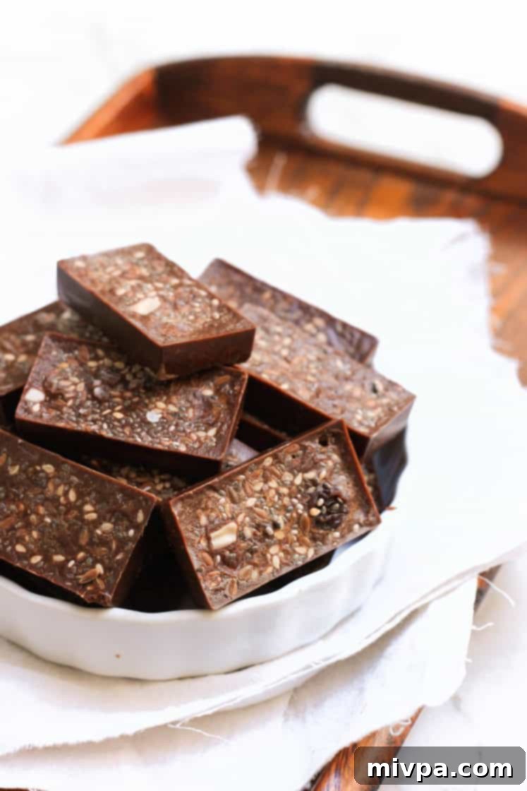 Easy Homemade Chocolate (Gluten-free, Vegan) Up close shot of homemade raisin and seed chocolate in a bowl.