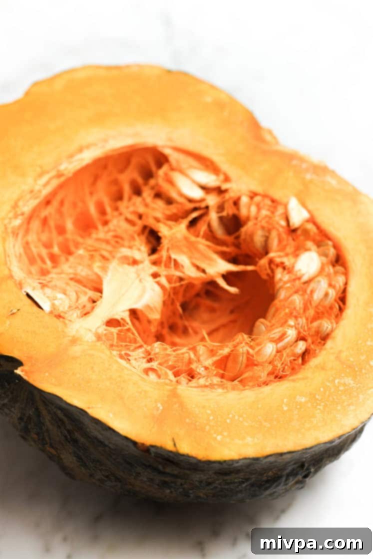 A fresh pumpkin, halved to show its vibrant orange flesh, ready for making puree.