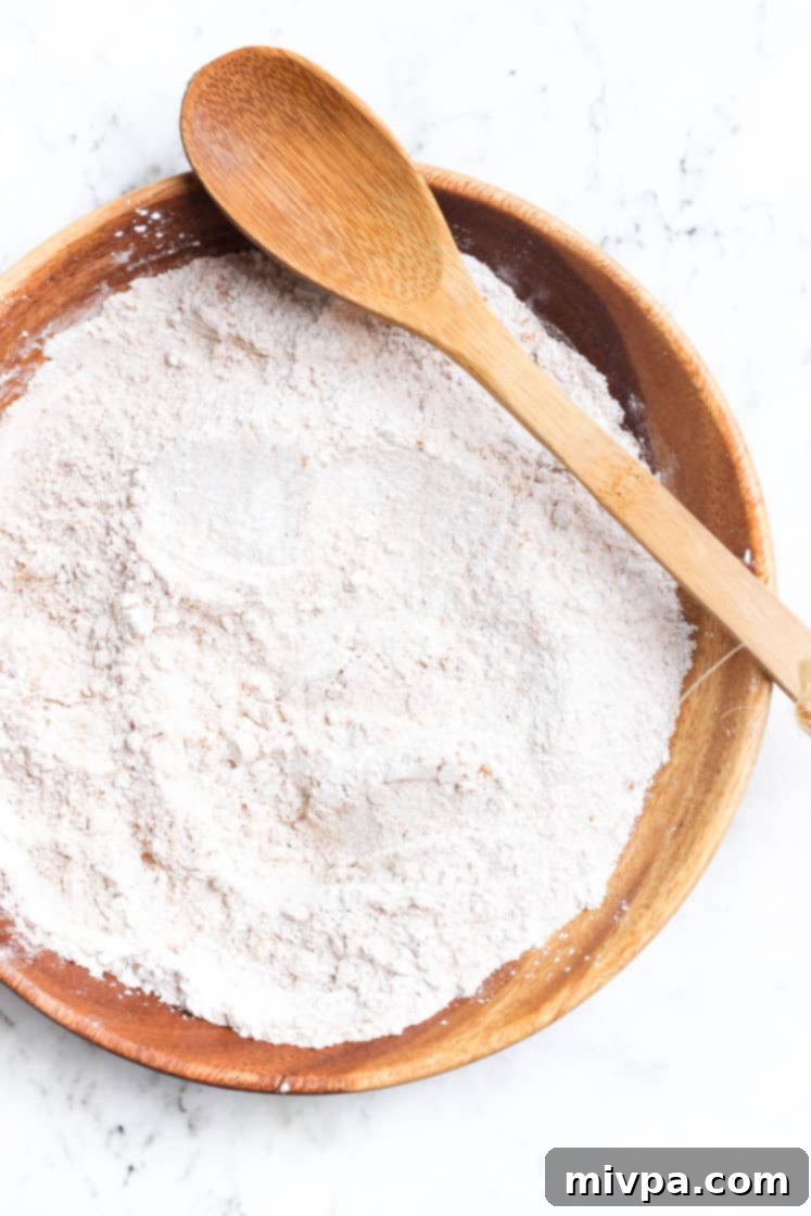 Dry ingredients for gluten-free pumpkin muffins, perfectly mixed together in a large wooden bowl.