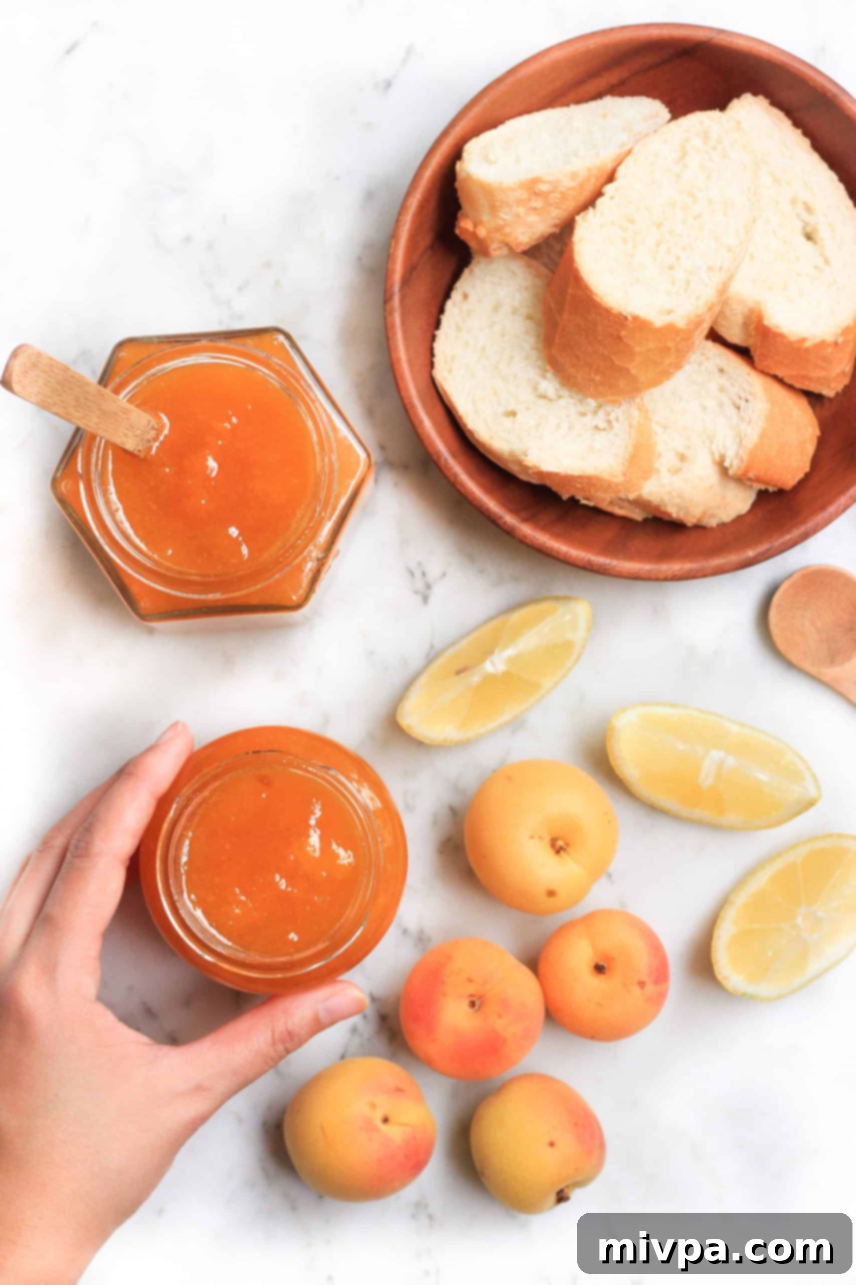 Hand reaching for fresh apricot preserves.