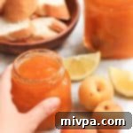 Hand reaching for jar of apricot jam