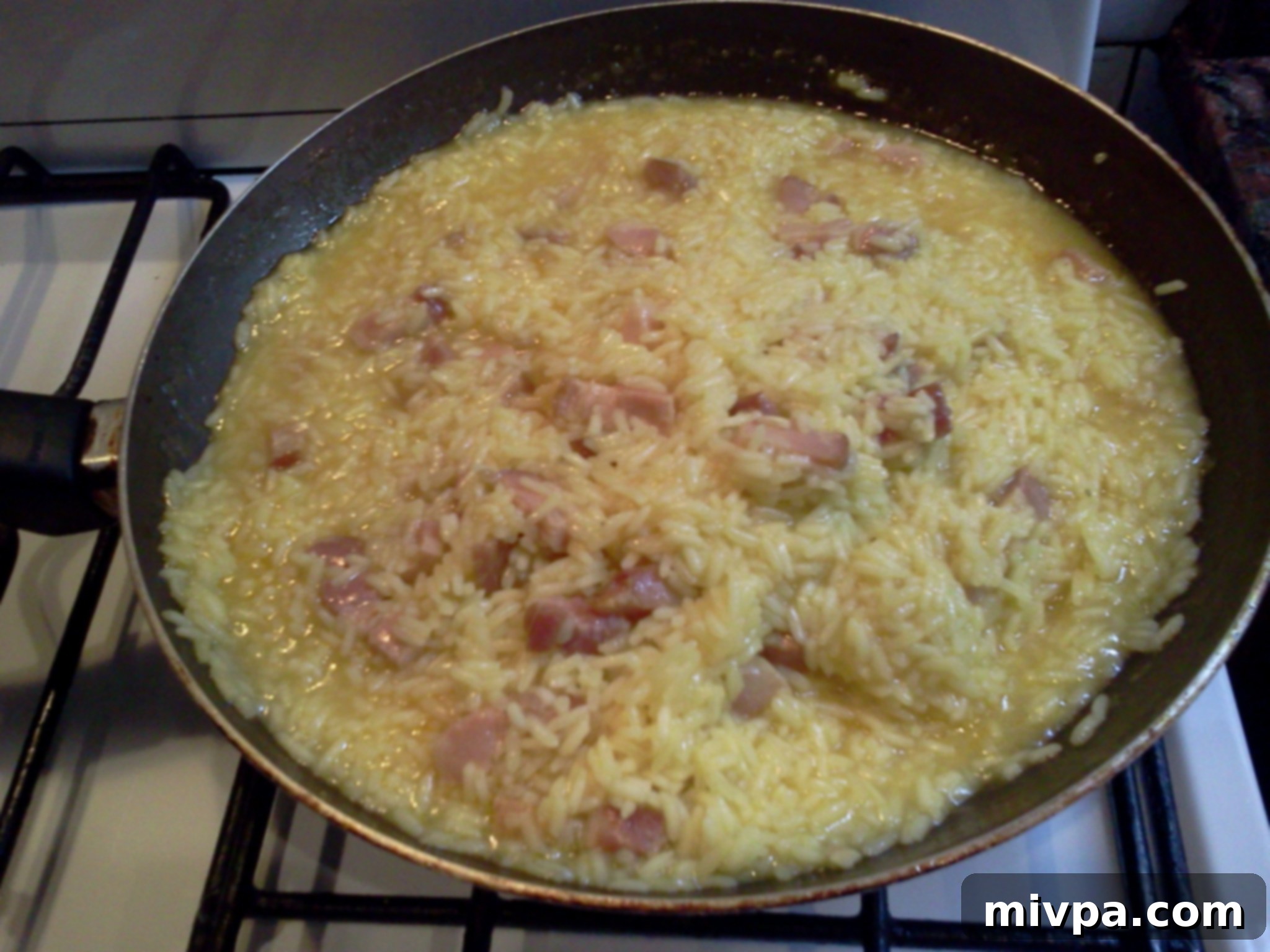 The saffron-infused rice is now fully cooked and fluffy in the pan, ready for the final step.