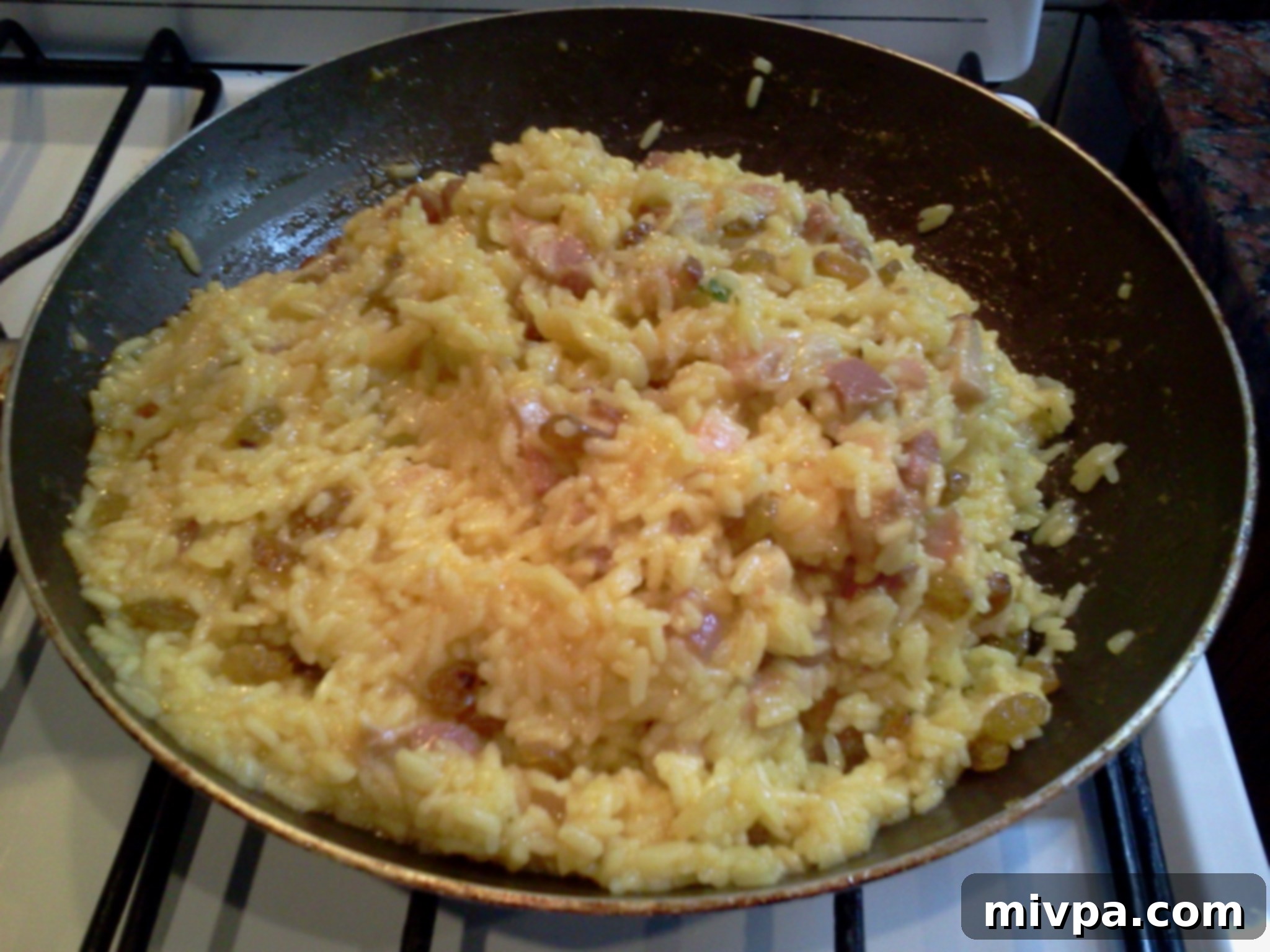 The rice and golden raisins being stirred together to ensure even distribution.