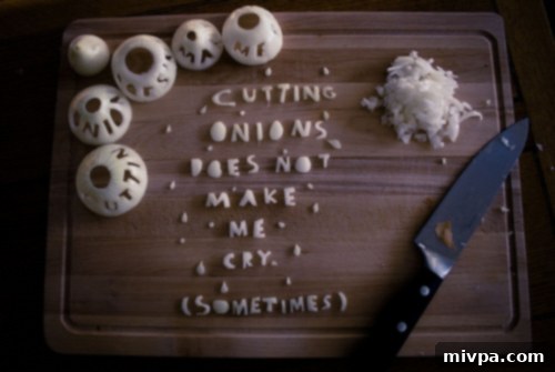 A person crying while chopping onions, a common kitchen predicament.