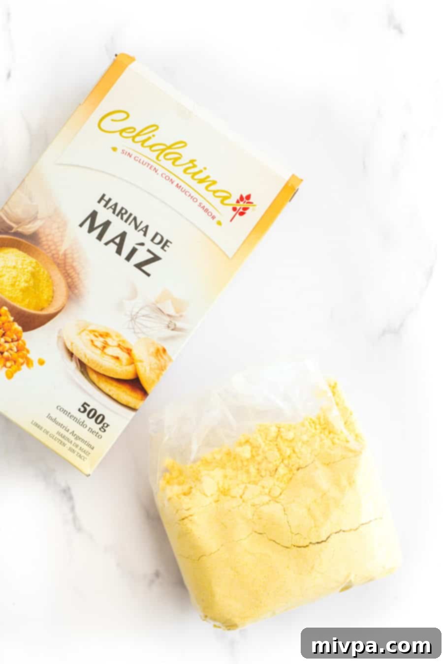 A packet of yellow corn flour rests on a elegant marble board, ready for baking.