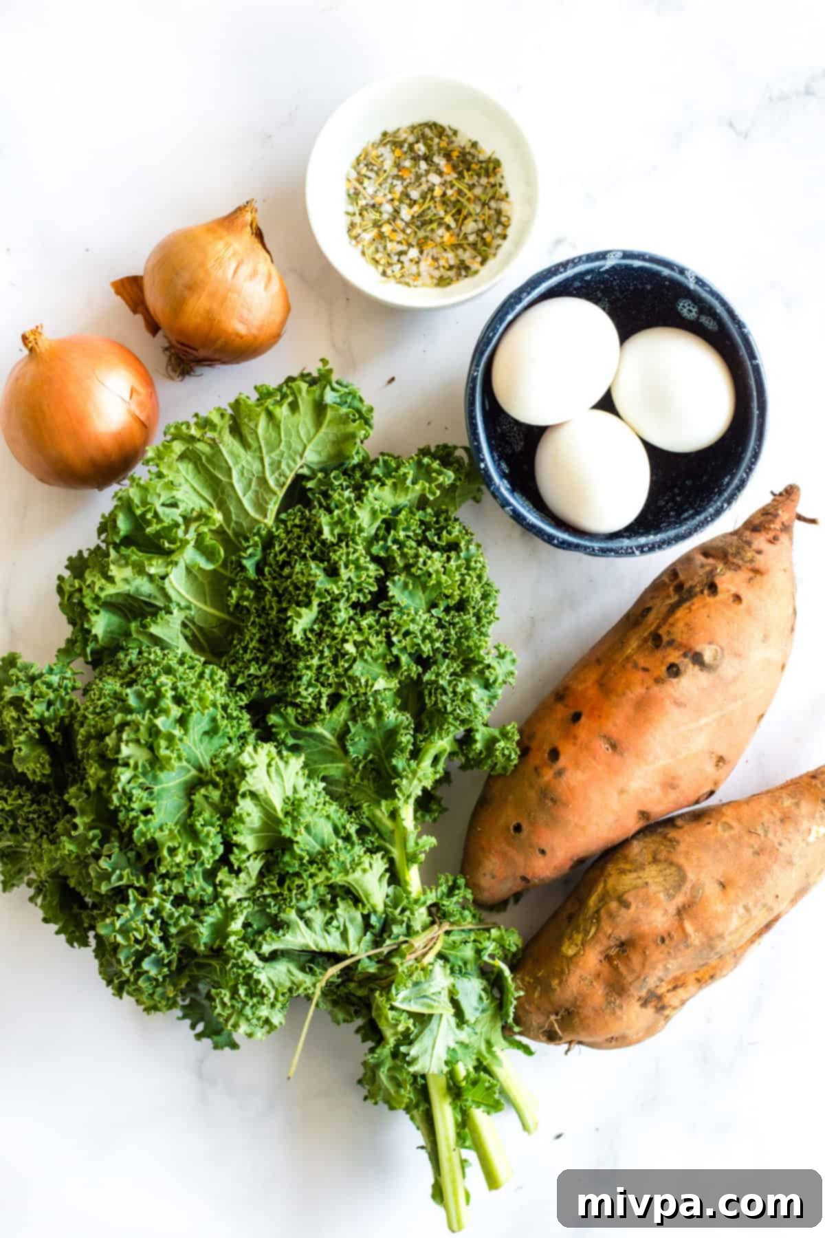 Fresh sweet potatoes and kale being prepared for the skillet meal.