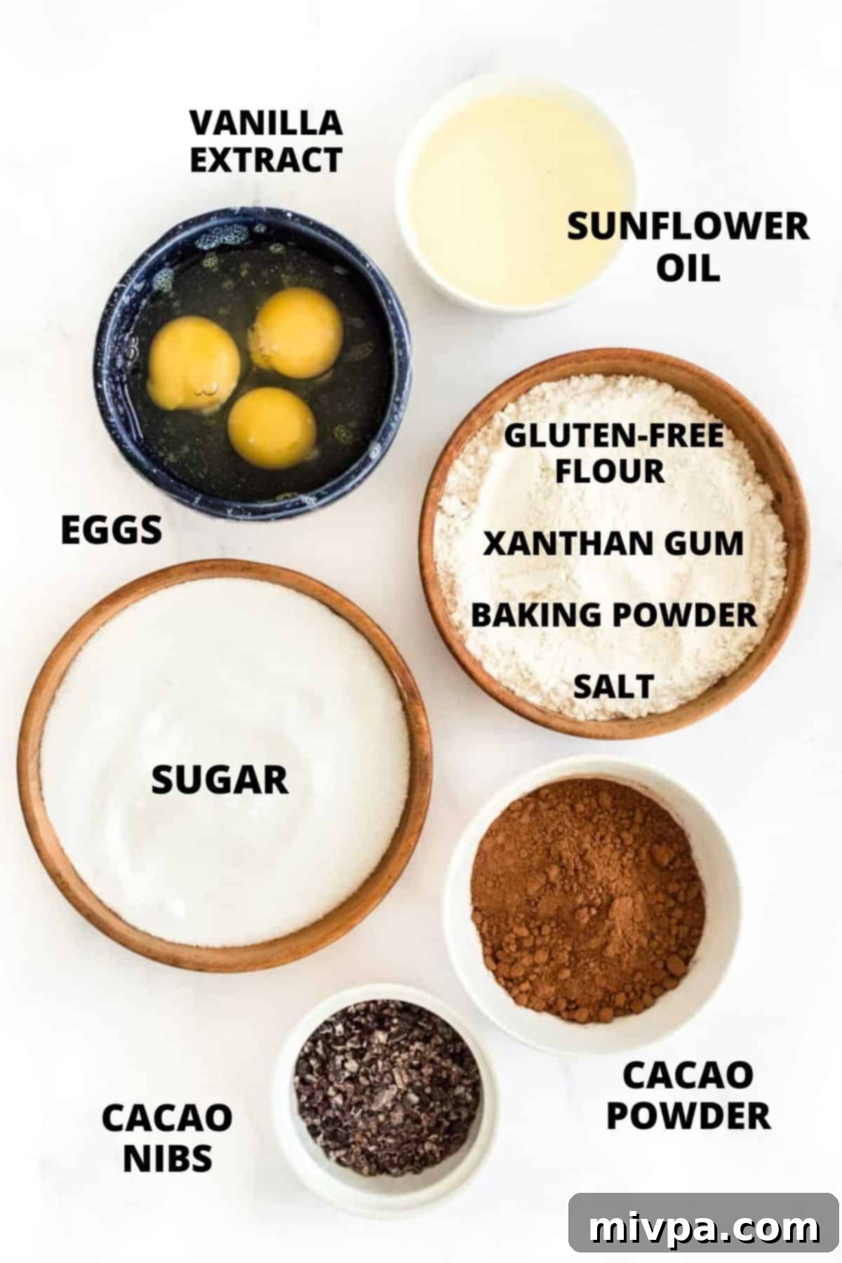 A flat lay photograph displaying all the fresh ingredients required for making the easy gluten-free dairy-free brownie recipe, neatly arranged on a white background.