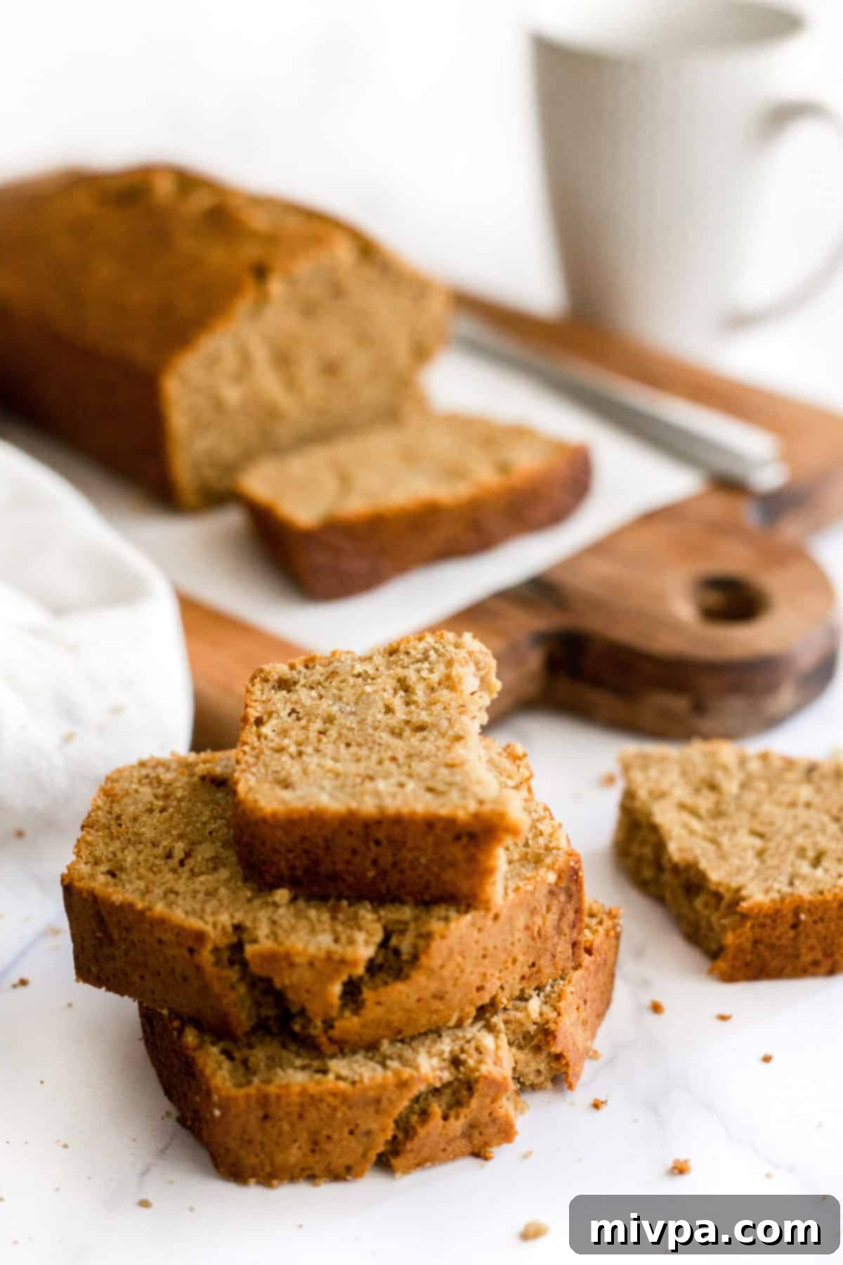A half-eaten slice of banana bread on a stack of slices.