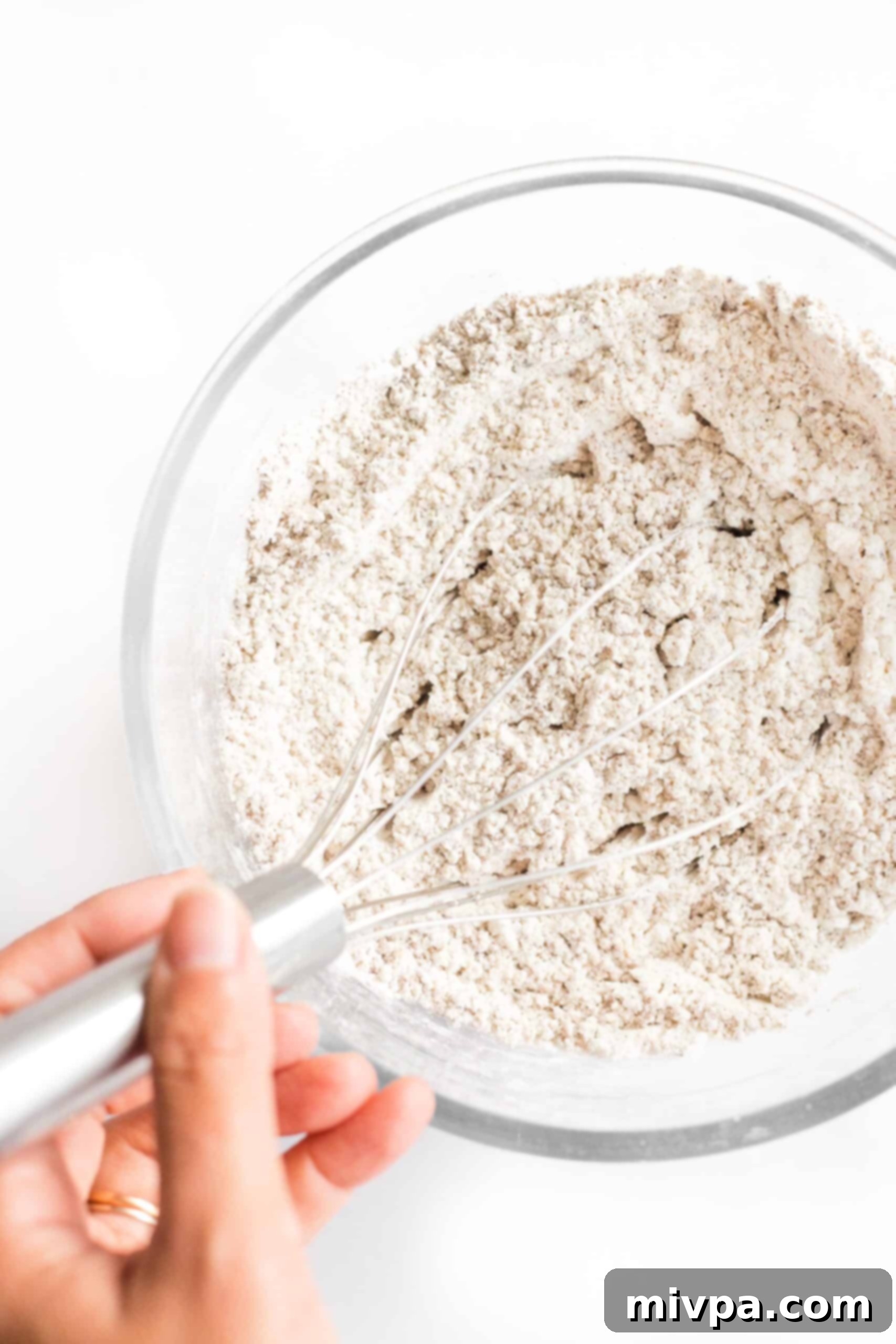 Whisking dry ingredients in a glass bowl.