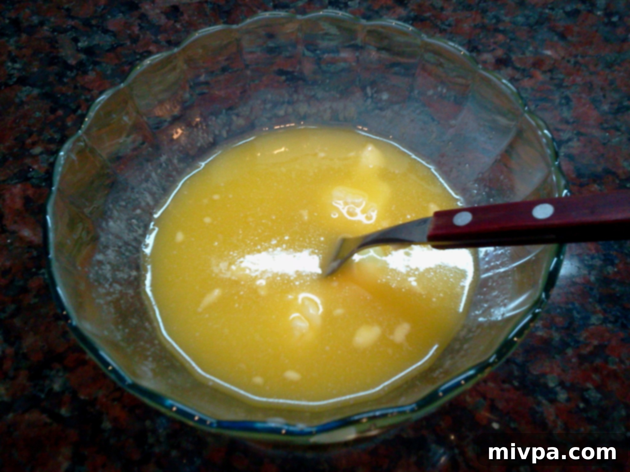 Smooth, golden melted butter in a bowl, prepared for the next step in making the alfajor dough.