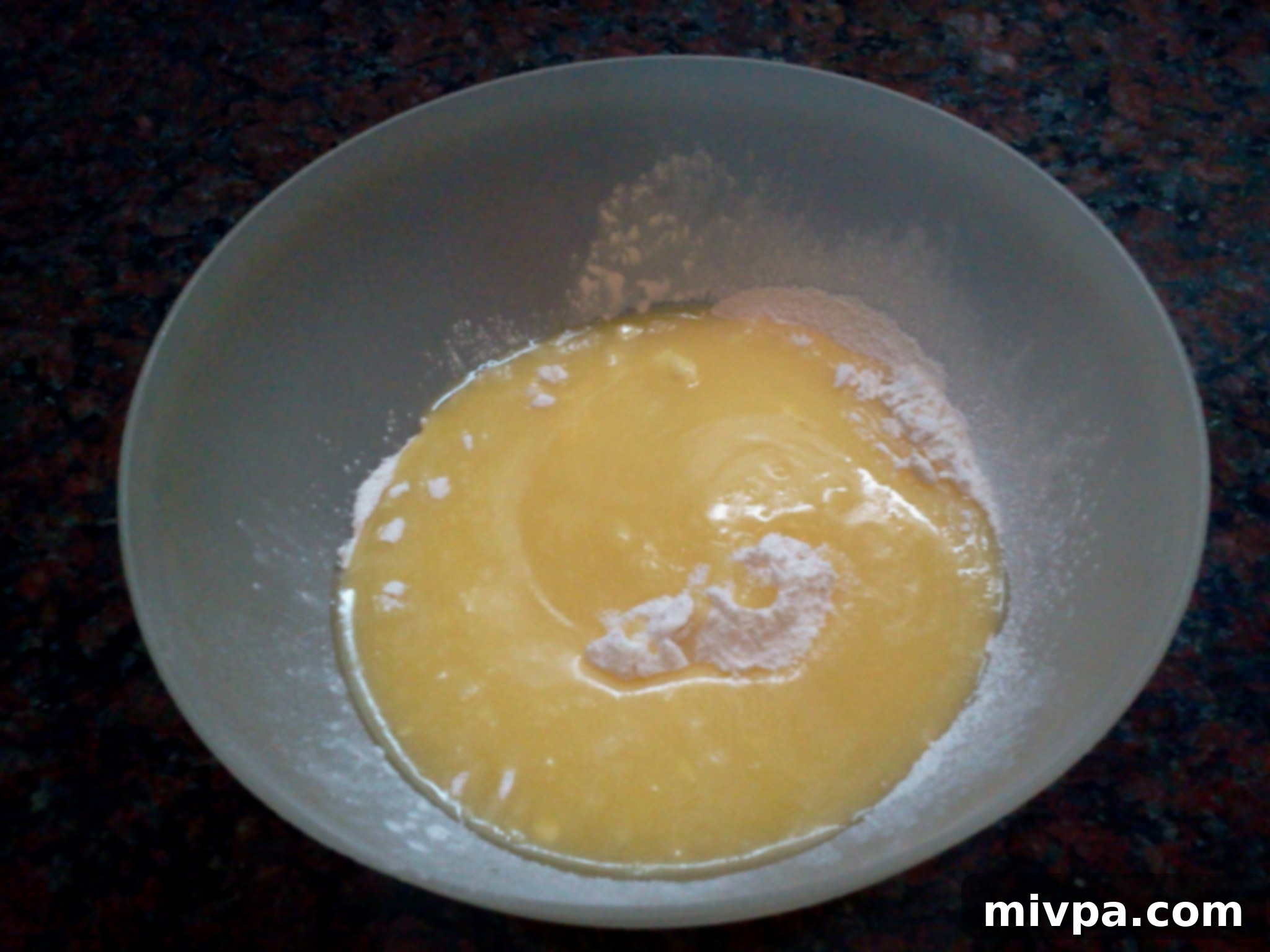 The liquid butter and sugar mixture being poured into a large bowl containing self-raising flour, initiating the dough formation.
