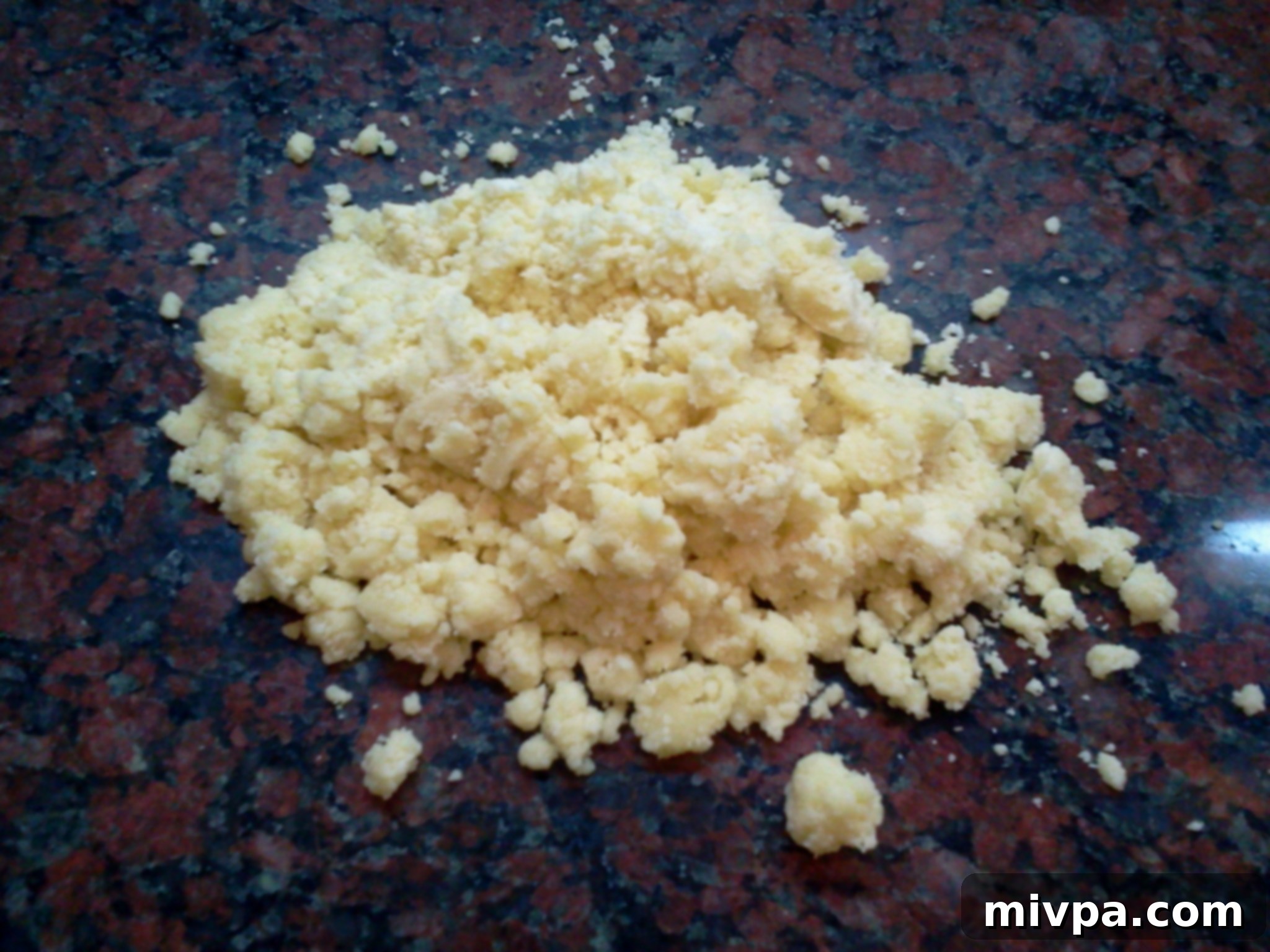 The soft cookie dough carefully spread out on a cool, flat surface, awaiting further preparation with a rolling pin.
