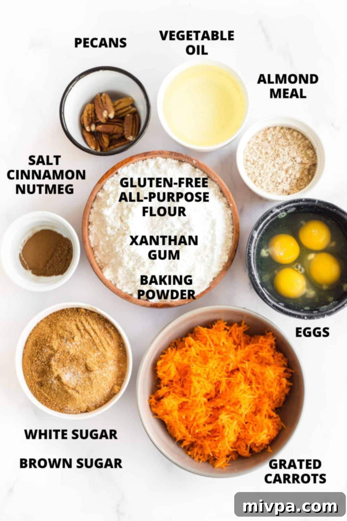 Top down view of ingredients for gluten-free carrot bread recipe on white board.
